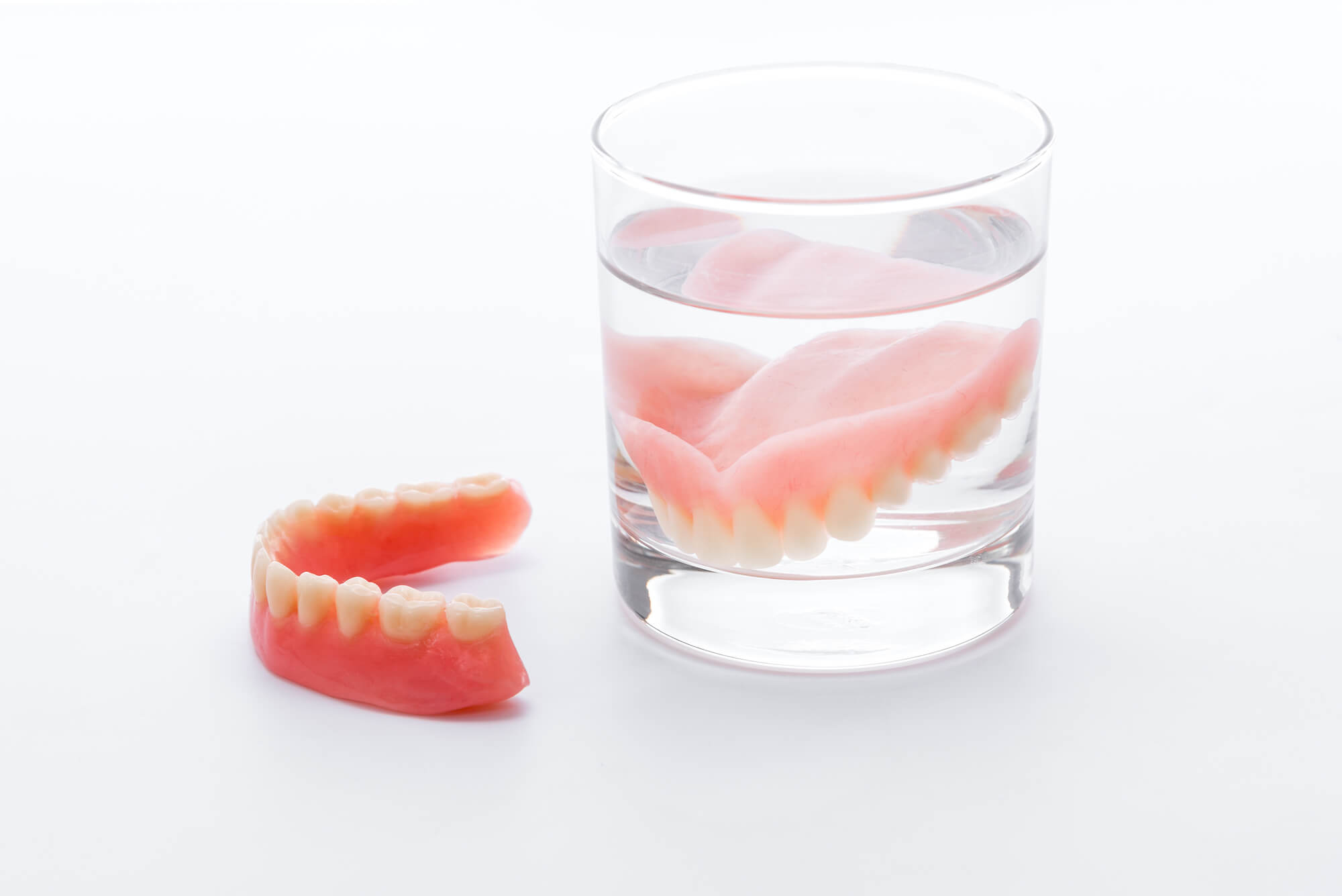 Dentures in Pompano Beach inside a glass of with denture solution
